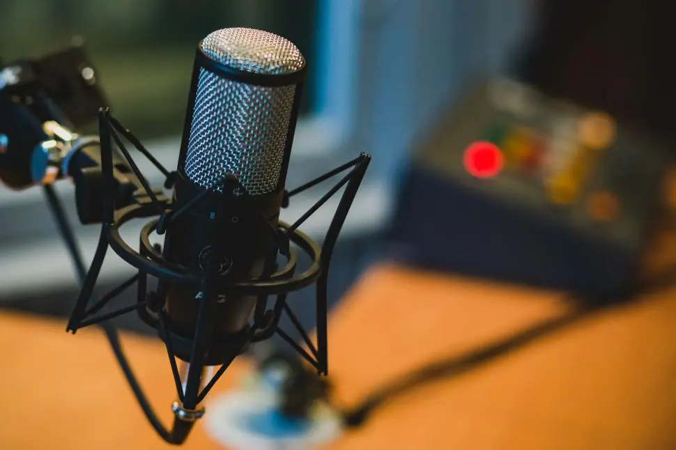 Podcast Audio Visual Services microphone setup with pop filter and audio interface gain staging for clean podcast recording.